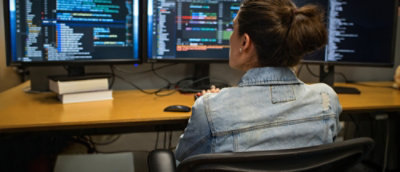 A person sitting at a desk looking at a computer screen.